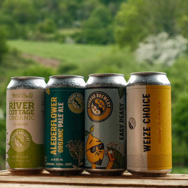 Four different beer options in cans from Stroud Brewery on a wooden surface with a natural background